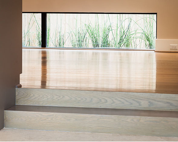 Low accent window in modern raised dining room for natural light and view of contemporary landscape