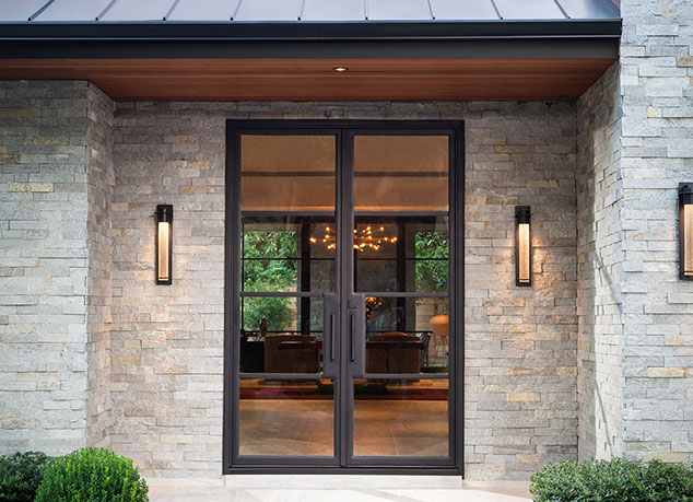 Custom glass and metal modern entry door at stone foyer